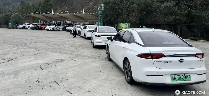 充電車位全都有電動車在充電，後面還排了至少 4 輛車等候充電。