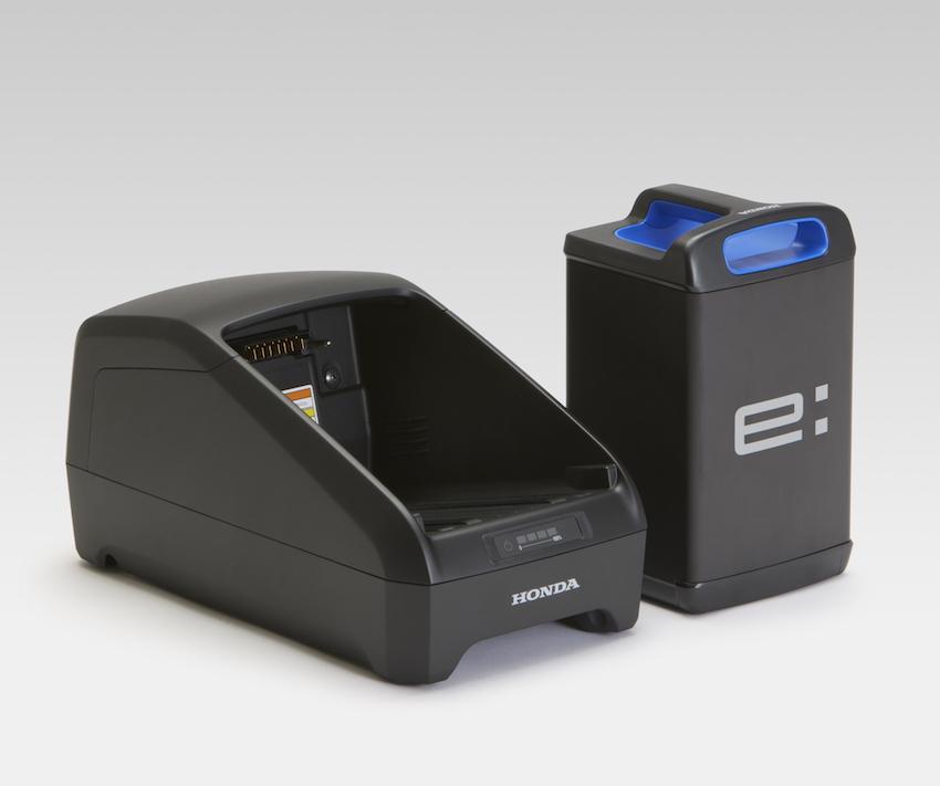 單顆 Honda Mobile Power Pack e: 電池（右）採抽取式，使用 Power Pack Charger e：充電座（左）進行充電。