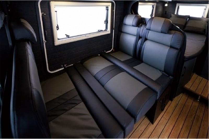 座椅中央設有高度可調的餐桌，向下收起並放上墊子即可當床舖使用。