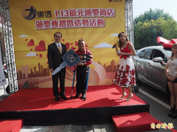 台彩總經理蔡國基（左1）代頒名車鑰匙給彩券行業者魏順正（左2）。（記者陳鳳麗攝）