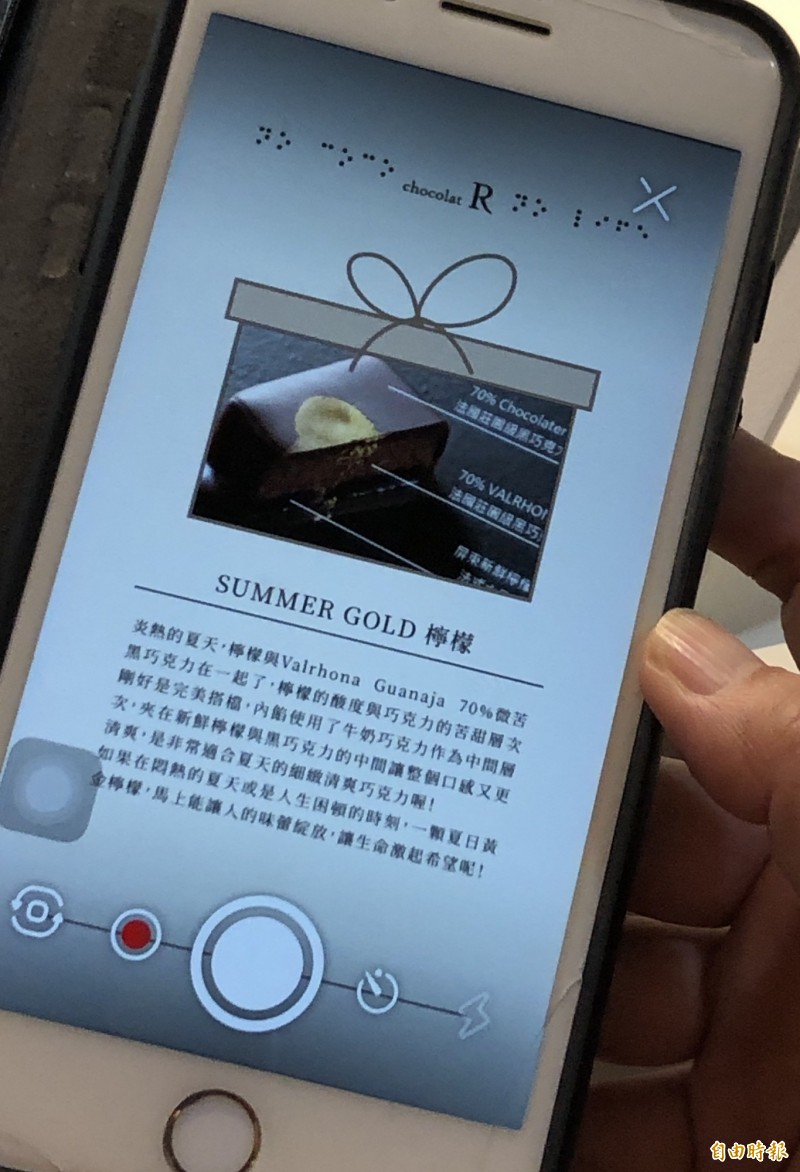 透過〈marq+〉APP的AR技術，每一張圖片都立刻變成有聲導覽，解釋每一顆巧克力Bonbon的背後故事。（記者陳炳宏攝）