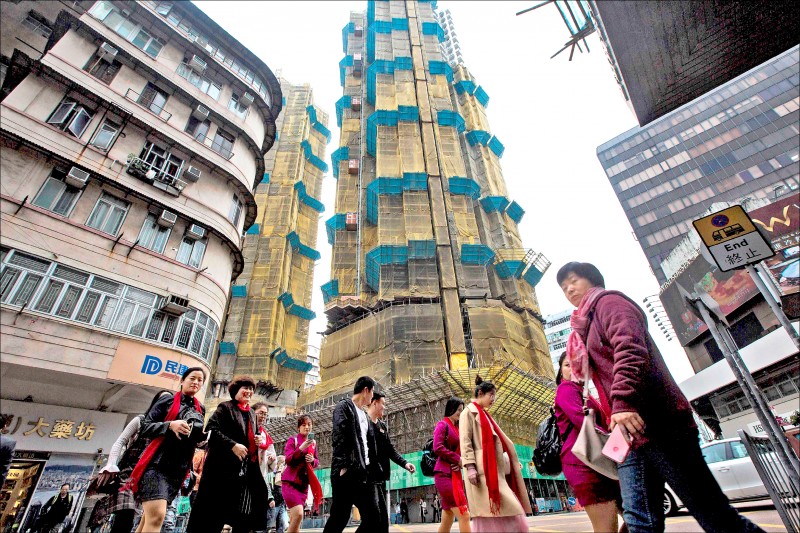 最新調查顯示，香港連續9年冠居全球最難以負擔的房市，民眾要不吃不喝「20.9年」才能買得起1間公寓。圖為九龍一處建案。（法新社）