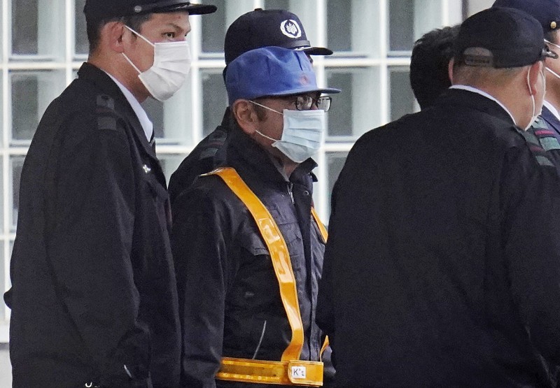 前日產汽車公司董事高恩昨日離開拘留所時的穿著(藍色帽子、口罩和工作服)與前來接他離開的麵包車座車引來注目。(彭博)