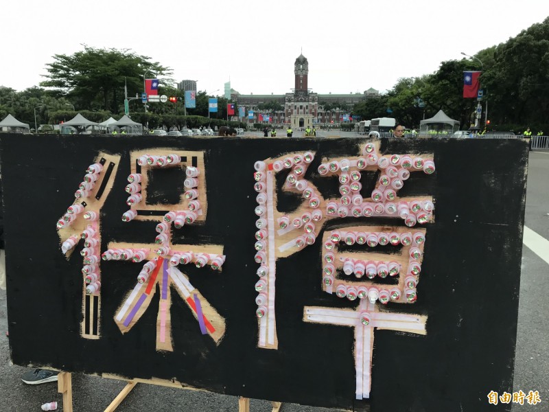 五一勞工大遊行用養樂多瓶排出「保障」二字。（記者李雅雯攝）