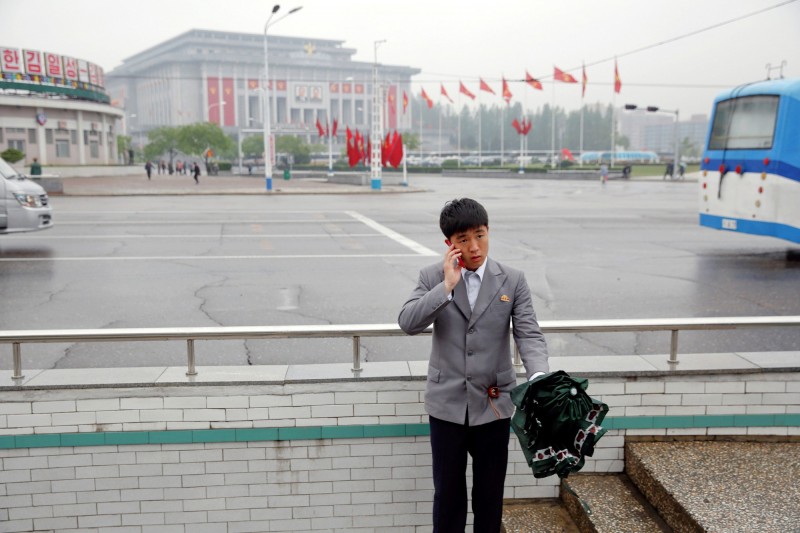 《路透》指出,北韓疑似透過中國私下貿易智慧型手機,此舉不僅規避聯合國制裁,還因此為北韓政府賺取可觀收入。圖為北韓民眾在4·25文化會館前以手機通話。(路透)