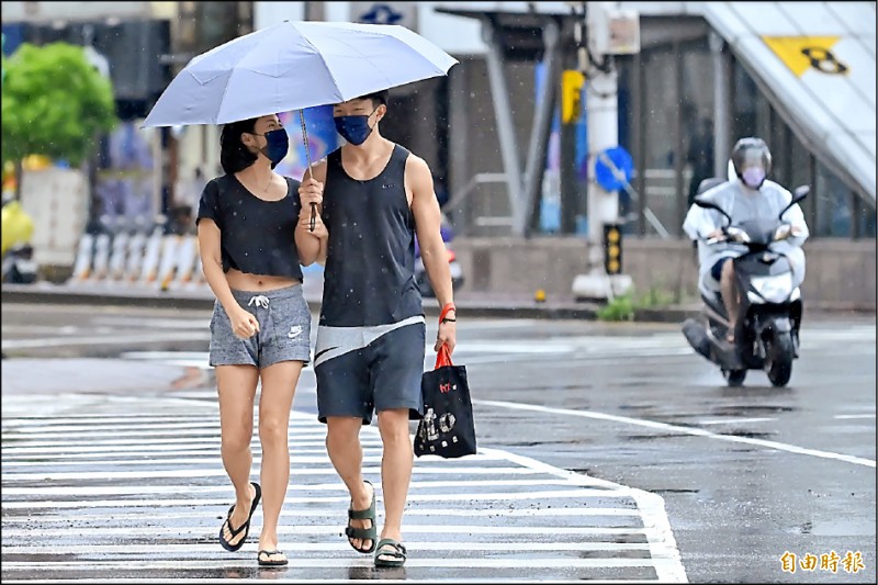 台灣持續受到梅雨鋒面與西南風影響，昨天北市雨勢雖趨緩，但還是持續下雨，外出的民眾除了攜帶雨具之外，更是防疫優先口罩戴牢。（記者陳志曲攝）