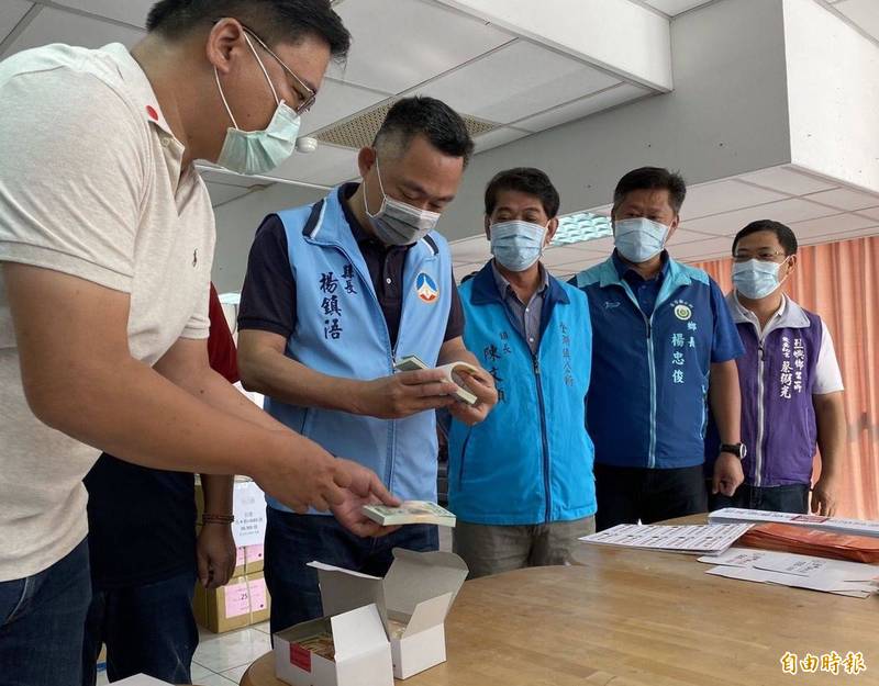 金門縣長楊鎮浯（右四）與各鄉鎮長前往點交最新出爐的振興券。（記者吳正庭攝）