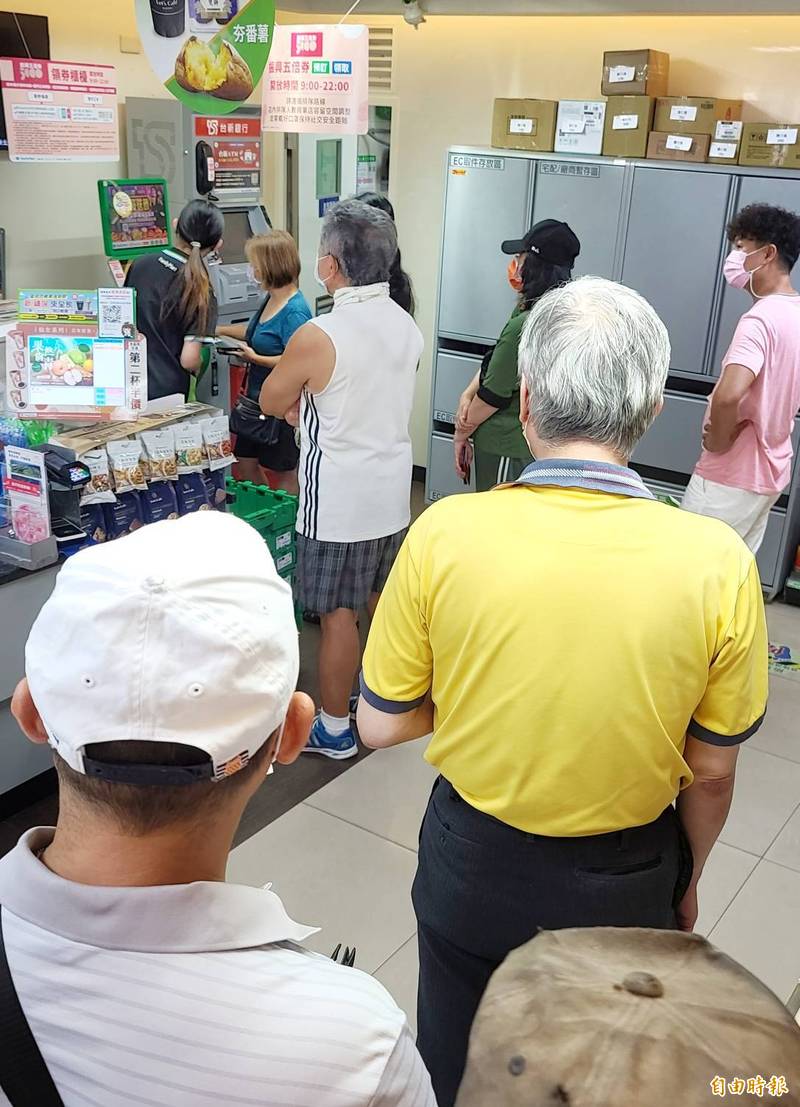 紙本5倍券今起領用,民眾前往超商排隊領取。(記者方賓照攝)