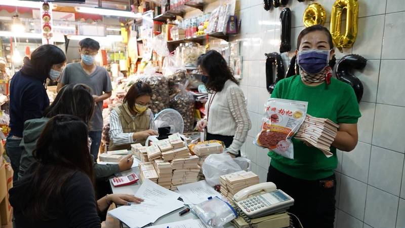 經發局派員到三鳳中街設服務據點，協助店家清點收取的商圈夜市券，加速兌換現金。（記者葛祐豪翻攝）