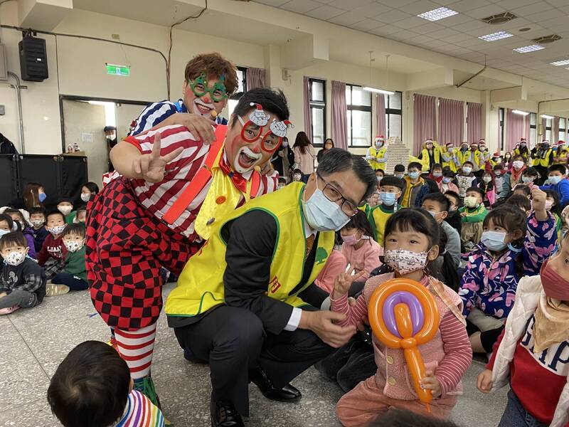 國泰世華銀行基金會董事長李明賢（中），開心發送禮物給現場學童。（圖/張躍榮攝）