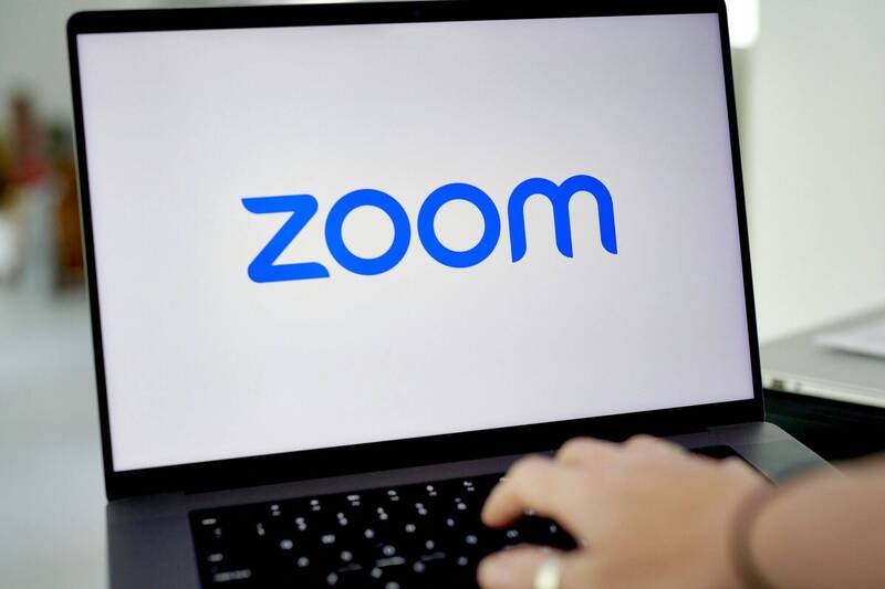 視訊會議平台Zoom因企業對遠距上班需求下降，也開始裁員及要求員工回辦公室上班。（彭博）