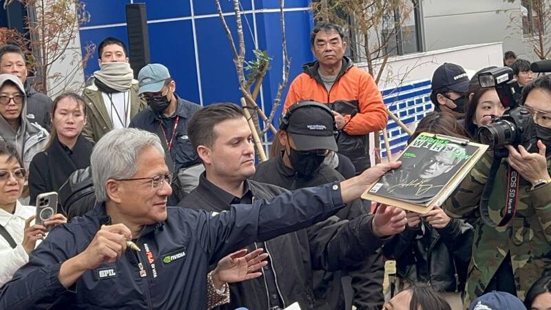 黃仁勳幫粉絲簽名。（記者廖耀東攝）