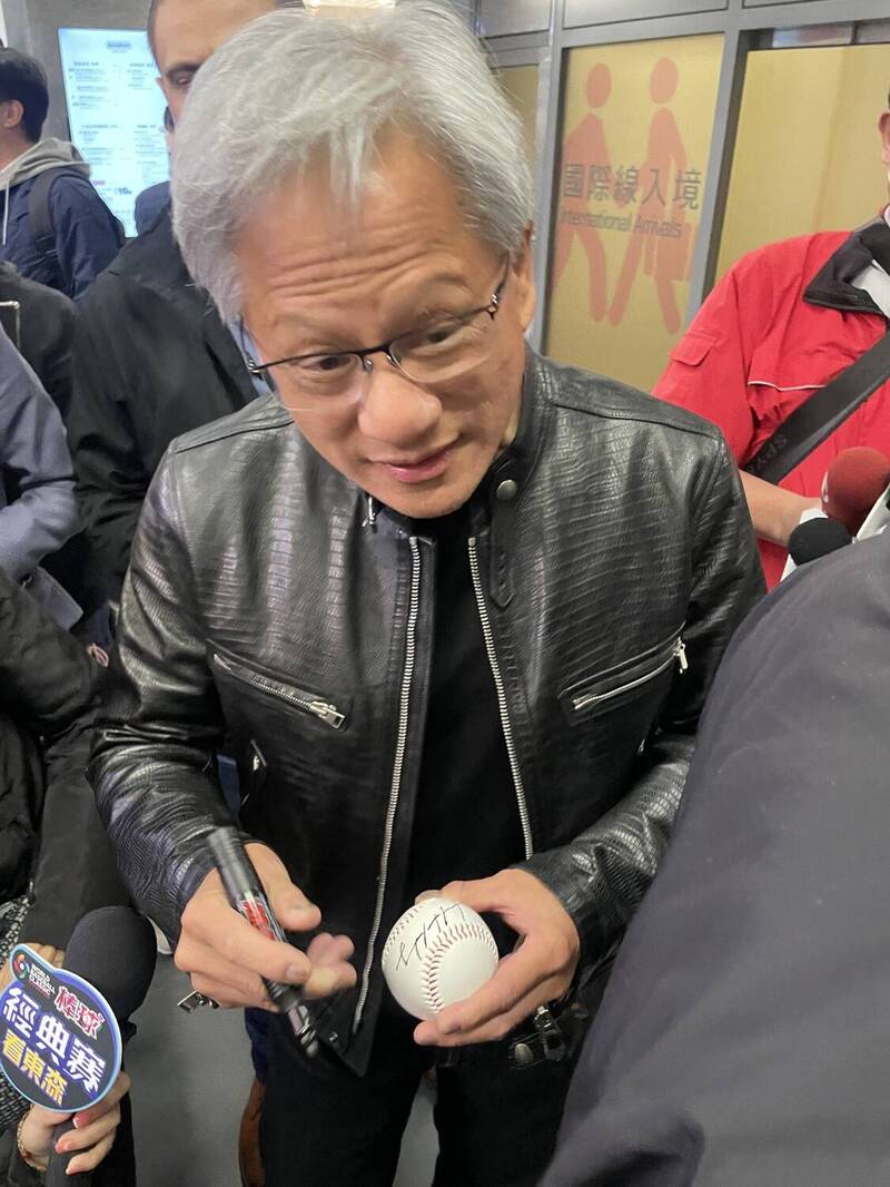 黃仁勳抵台中機場，幫粉絲在棒球上簽名。（民眾提供）