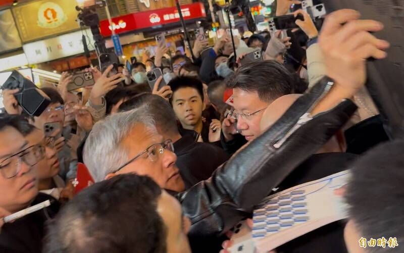 黃仁勳逛逢甲夜市周圍擠滿民眾，他仍親切打招呼、合照、簽名、握手。（資料照，記者蔡淑媛攝）