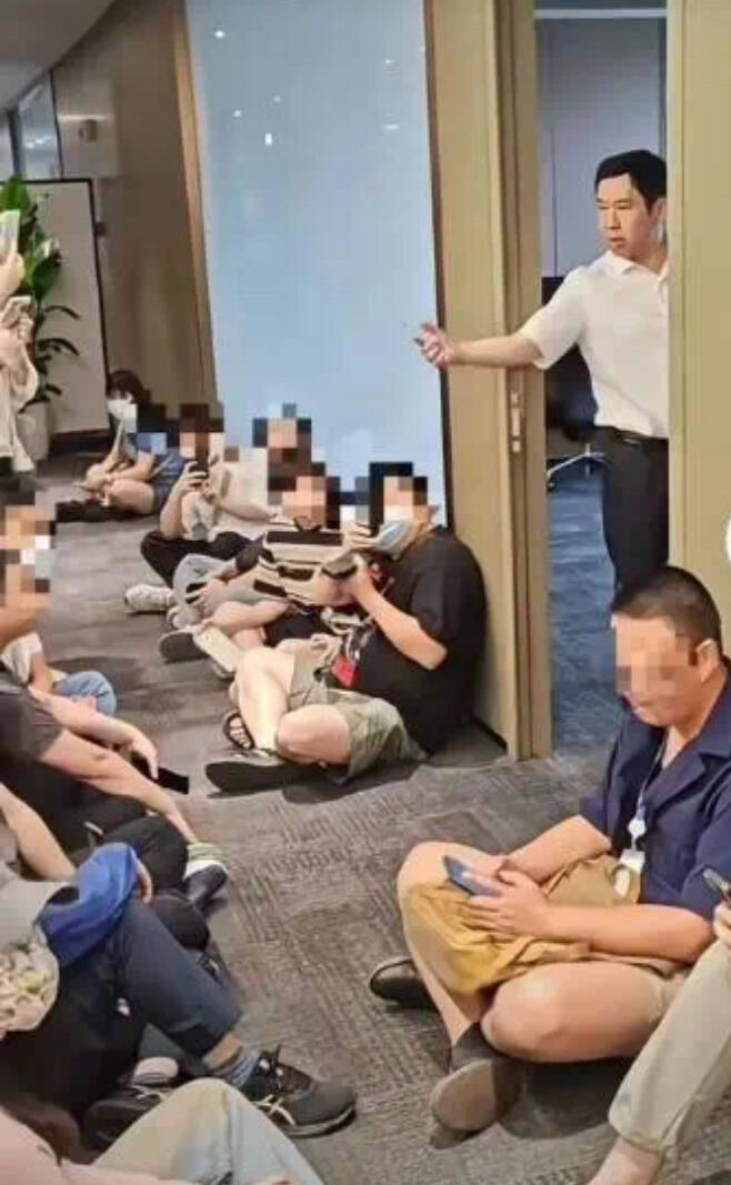 哪吒汽車員工不滿被欠薪，圍堵哪吒汽車母公司合眾新能源董事長方運舟（站立者）。（圖取自中國社交平台）