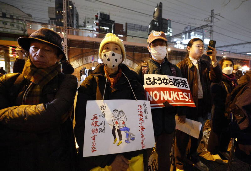 福島核災14周年，民眾在福島第一核電廠的營運商東京電力公司總部大樓前舉行抗議活動。（資料照，歐新社）