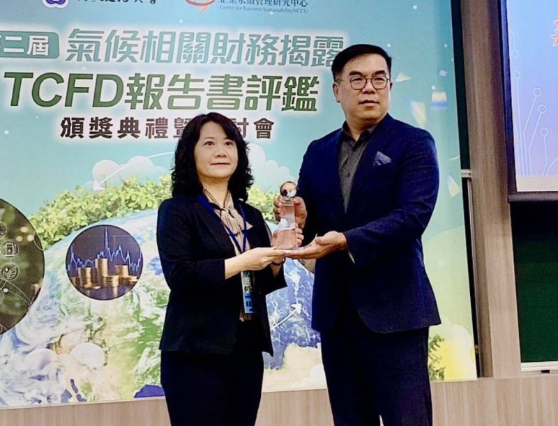 新安東京海上產險總經理賴麗敏（左）接受TCFD報告書評鑑優異獎項，右為環境部長彭啓明。（業者提供）