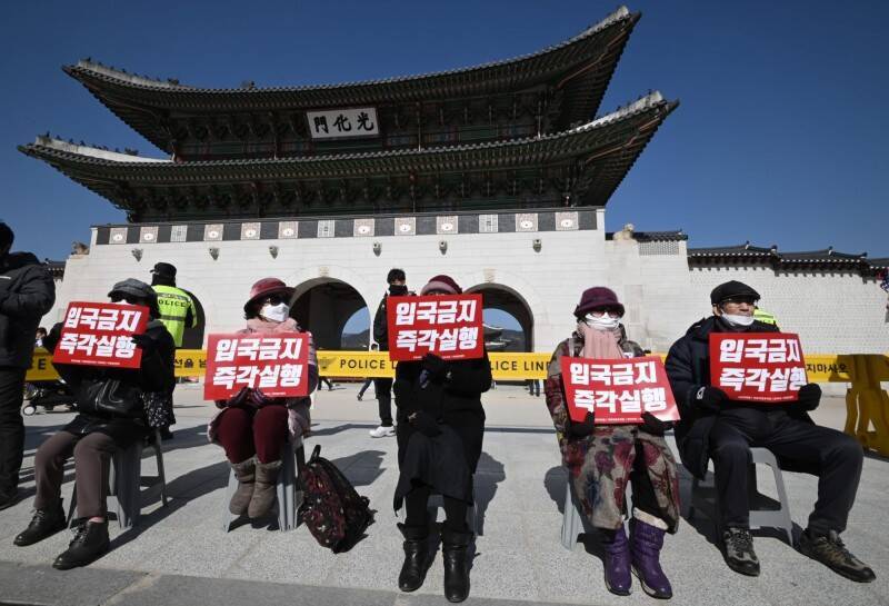 2020年，南韓民眾舉著「立即禁止入境」標語，呼籲政府禁止中國人進入南韓。（法新社資料照）