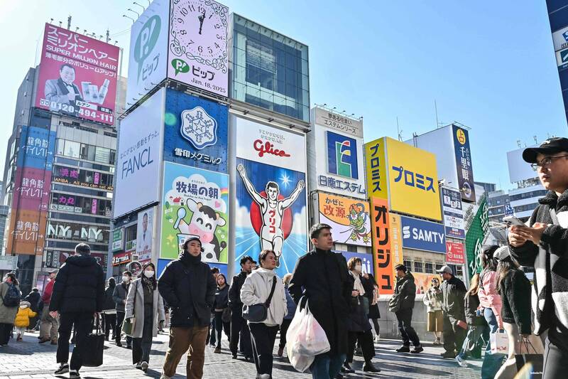 大阪南區平日依舊人潮洶湧，位於「固力果霓虹招牌」附近的戎橋、心齋橋筋商店街上，滿街都是拖著行李箱的外國遊客。示意圖。（法新社）