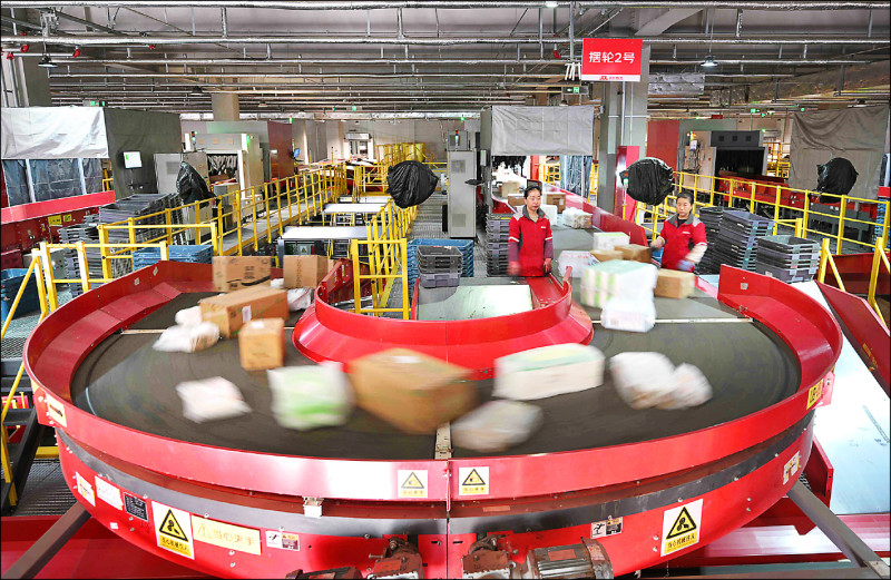 中國雙十一購物節近尾聲，卻未激起消費者的熱情，過往各大購物平台會舉辦盛大活動慶祝銷售金額刷新紀錄，但迄今仍按兵不動。圖為京東倉庫的工人們正在分揀包裹。 （法新社）