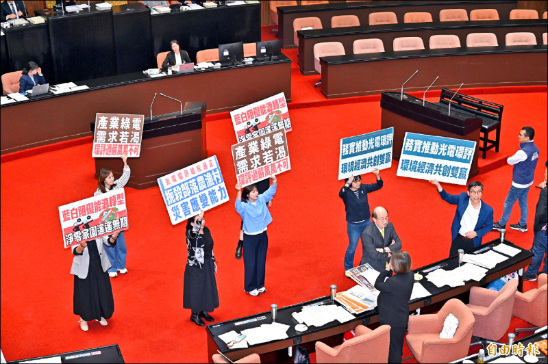 在民眾黨與國民黨聯手下，立法院會昨天三讀通過光電三法修正案，民進黨團舉牌反對。（記者塗建榮攝）
