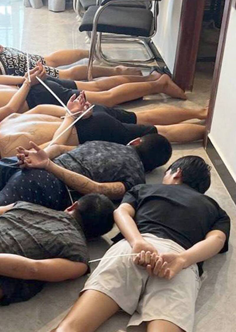 金邊一家詐騙中心遭到警方突襲後，嫌疑人被拘留。（法新社）