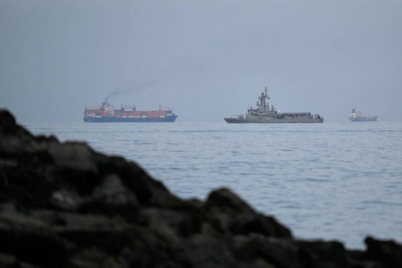阿聯正在積極研究如何在保護荷姆茲海峽的行動中扮演軍事角色，包括排雷及提供其他支援服務。圖為一艘阿聯海軍艦艇在荷姆茲海峽與一艘貨船並排航行。（法新社）