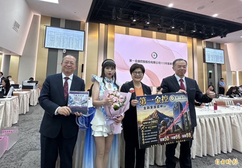 第一金股東會資深股東黃雪芬獻花鼓勵經營團隊。由右至左分別為第一金總座方螢基、董事長邱月琴、黃雪芬以及一銀總經理周朝崇。（記者陳梅英攝）