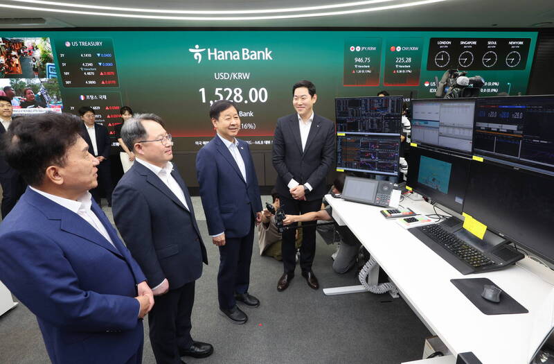 南韓財政部長具潤哲（Koo Yun-cheol，右二）今在韓亞銀行24小時美元交易系統啟動儀式上，視察外匯交易流程。（歐新社）