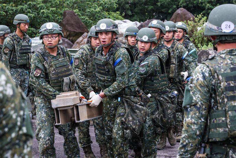 受測的工1連官兵合力搬運滾具樑橫梁，方便後續的推橋引進作業順利進行。（青年日報提供）
