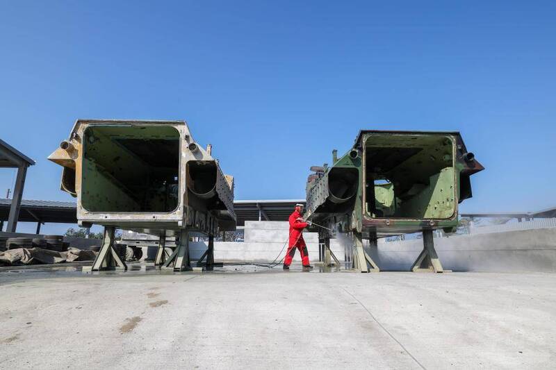 官兵在空曠處實施AAV7車殼水刀除漆、除鏽作業。（圖片取自軍聞社）