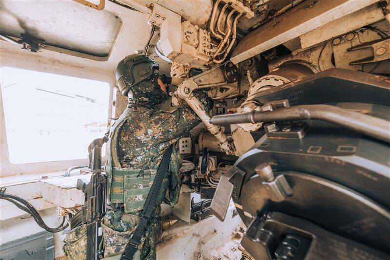 在M109的戰鬥艙內，瞄準手、副瞄準手操作週視鏡、射角儀，進行方向、射角等諸元裝訂，瞄準敵傘兵位置及重要路口進行封鎖。（圖片擷取自青年日報）