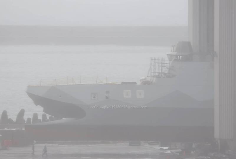 完工的沱江級艦體在工作人員的引導下，緩慢從棚廠內移動到室外的碼頭邊。可見艦體仍留有接續施工所需的鷹架，武器與雷達等部分也尚未安裝。（李忠衛授權提供）