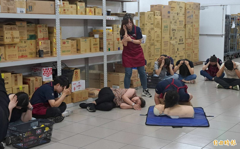 模擬避難時，發生民眾身體不適、昏倒等意外的處理作業，過程逼真。（記者蔡文居攝）