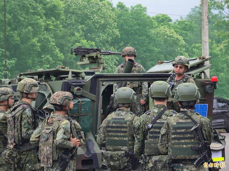 關指部火力連向召員（頭盔無迷彩者）解說迫砲車「故障排除操演」細節。（記者方瑋立攝）