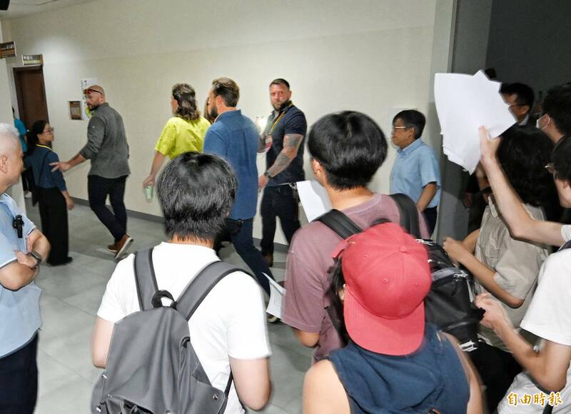 Anduril執行長帕爾默（左前著黃綠襯衫者）準備走進講堂演說，遭遇場外人士抗議，譴責他以軍火資助以色列對巴勒斯坦人民進行種族滅絕。（記者方賓照攝）