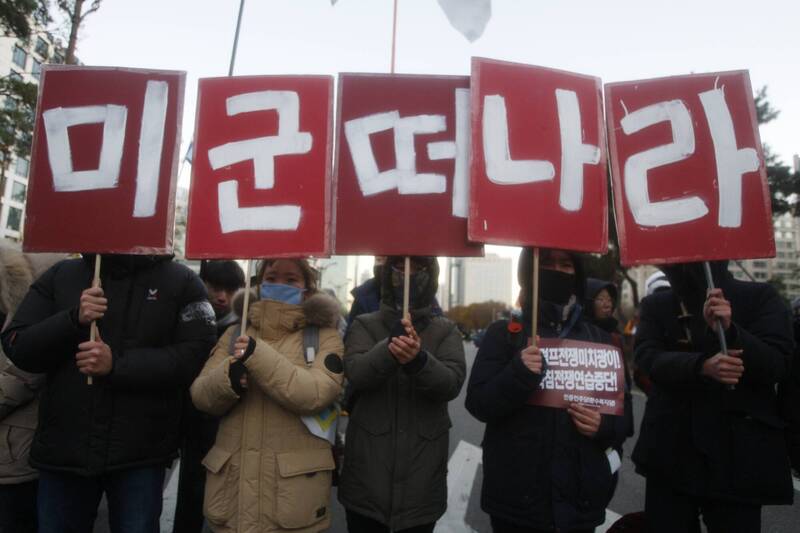 南韓民眾在2017年高舉標語，抗議薩德系統進駐該國。（歐新社檔案照）