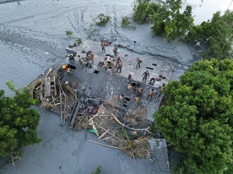 這是軍聞社空拍畫面的另一個角度，可以發現軍方搜救人員在頂上開了大大小小約十個洞口，官兵冒險輪班進入屋內。（圖：國防部發言人臉書專頁丶軍聞社）