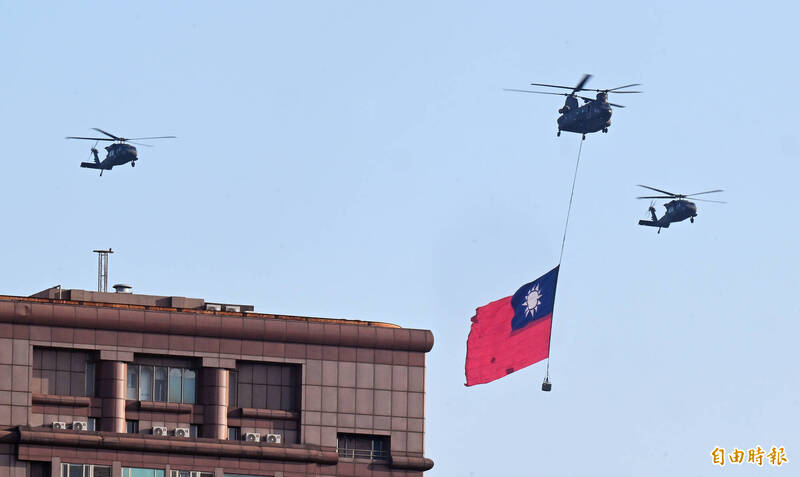 國慶大會全兵力空中操演8日舉行，CH-47SD與UH-60M直升機組成國旗機隊，吊掛大幅國旗飛越總統前廣場。（記者廖振輝攝）