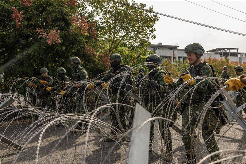 官兵迅速展開蛇腹型鐵絲網，於主要道路交會處建立阻絕設施。（圖取自青年日報）