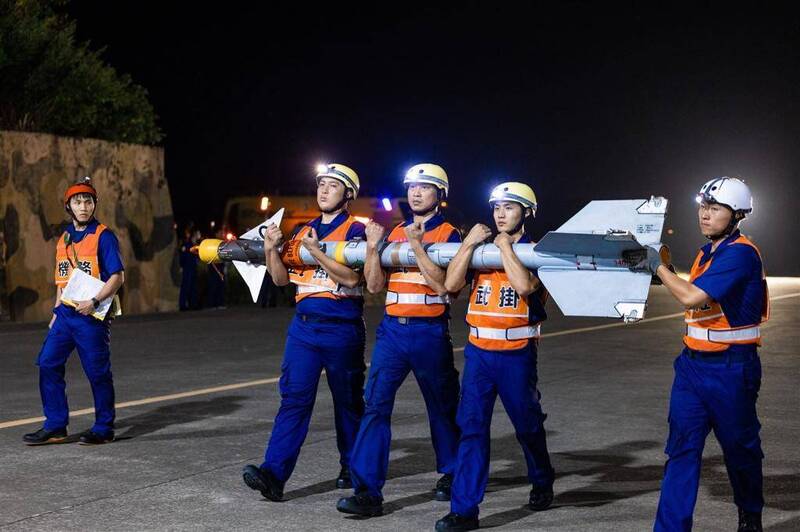 官兵搬運AIM-9M響尾蛇飛彈。（圖取自青年日報）