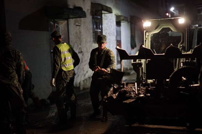 國軍在深夜時段化身為「黑夜騎士」，穿梭街巷與積水區域清淤，為民眾開闢安全回家的路。（軍方提供）