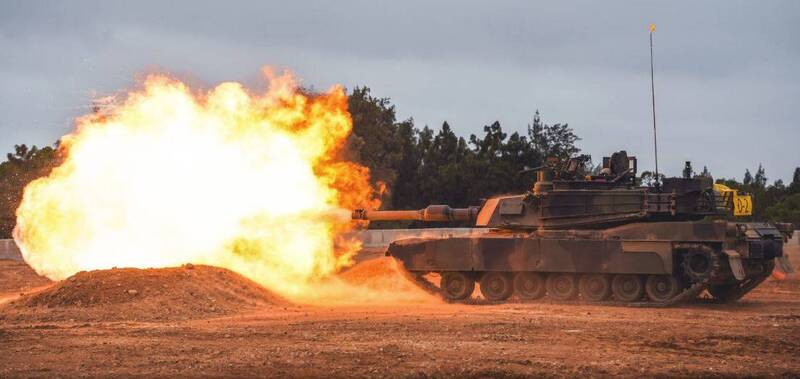 M1A2T戰車砲口迸發熾熱火光，揚起陣陣塵土，震撼聲響徹訓場。（圖：取自青年日報）