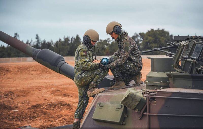 官兵合力將120公厘戰車砲運上戰車。（圖：取自青年日報）