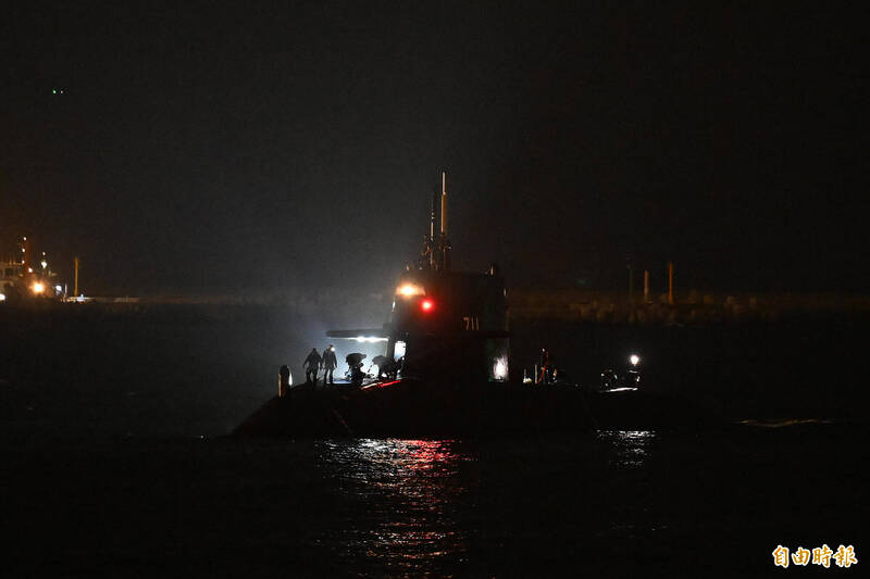 測試人員在燈光下執行相關作業。（記者李惠洲攝）