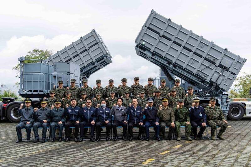 賴總統與「海軍海鋒7中隊」官兵合影，總統 身上穿的是印有總統府外觀圖案的灰色夾克。後方的龐大飛彈發射箱，是雄風二型反艦飛彈。（圖：軍聞社提供）