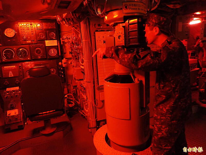 潛艦駕駛艙開啟「紅燈模式」（Rig for Red），海上自衛隊員模擬使用潛望鏡情況。（記者陳鈺馥攝）
