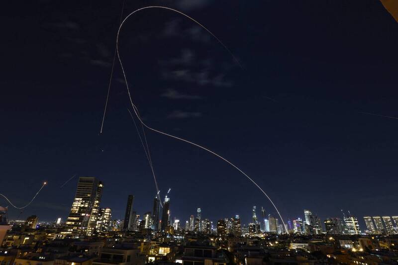 以色列鐵穹防空系統攔截飛彈於2月28日特拉維夫夜空留下交織軌跡。面對真主黨100枚火箭彈的飽和攻擊，這套防線的攔截率在極限壓力下還是有點吃力。（法新社）