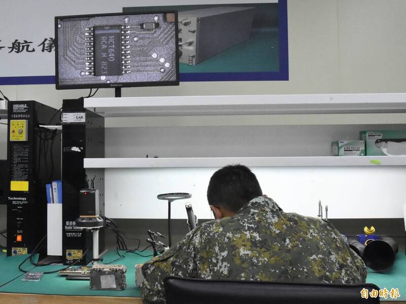 官兵放大檢視電路，並且進行焊修。（記者吳哲宇攝）