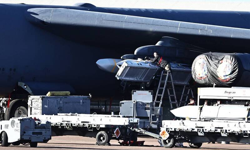 美軍官兵在B-52轟炸機上，掛載AGM-158飛彈。（法新社檔案照）